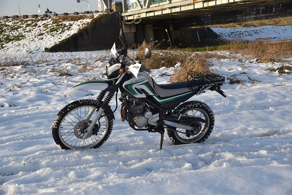 ヤマハのオフロードバイクのセロー250が雪の上に停まっている様子
