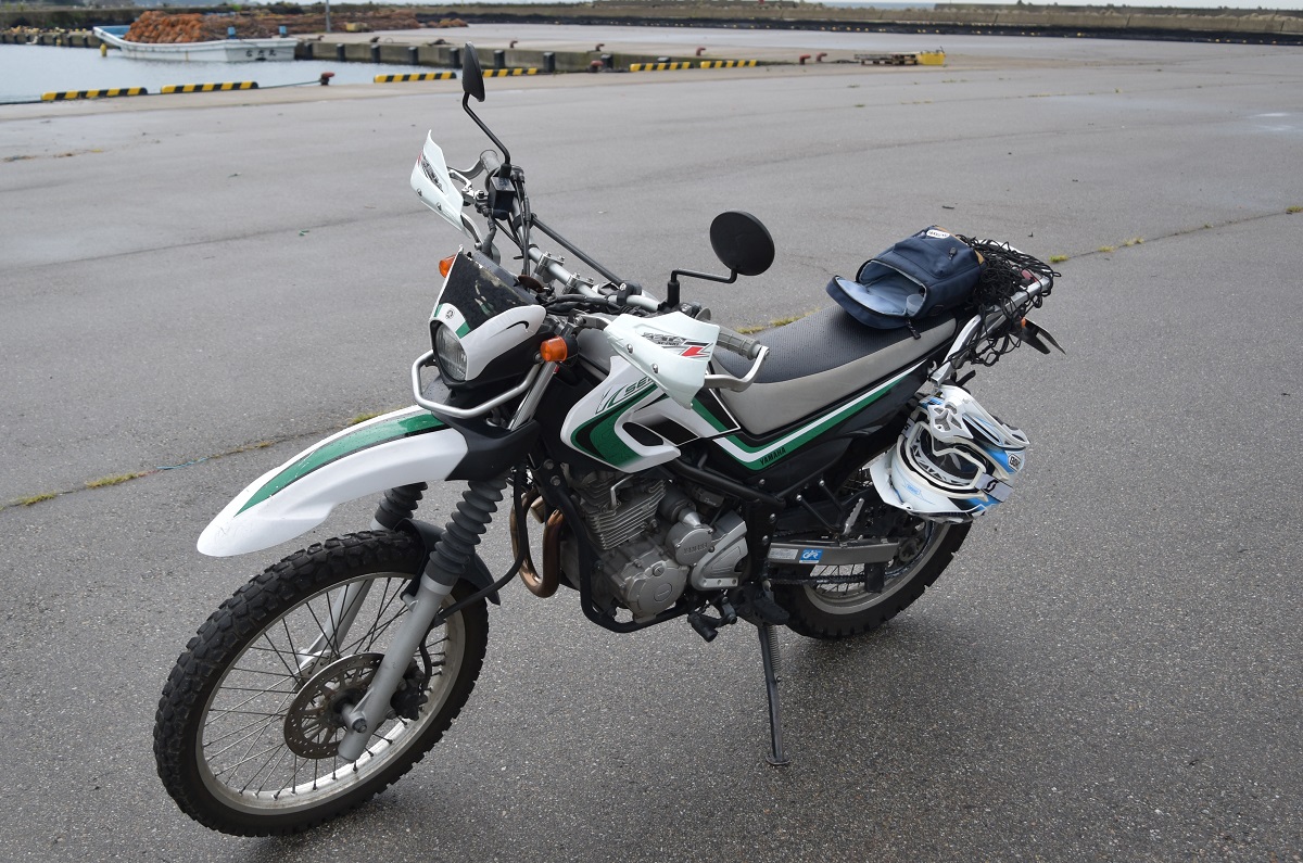 漁港付近の広場に停まっているヤマハのオフロードバイクのセロー250