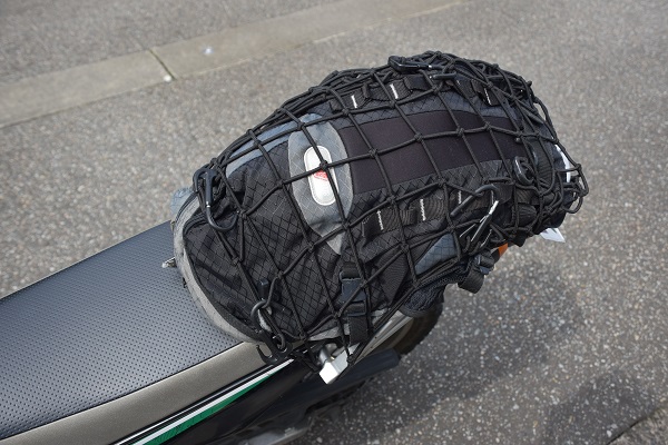ネットフックでバイクのリアシートの上に固定されているリュックサック