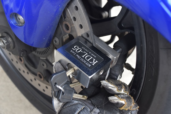 キタコのディスクロックのKDL-05をバイクのディスクローターに取り付ける様子