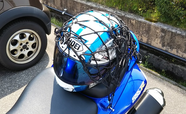 バイクのヘルメットがネットフックで固定されている様子