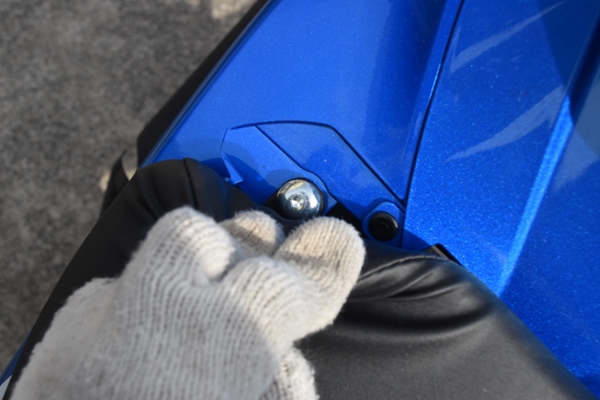スズキ バイク 原付二種 GSX-R125 シートの端を指で持ち上げている様子 ボルト