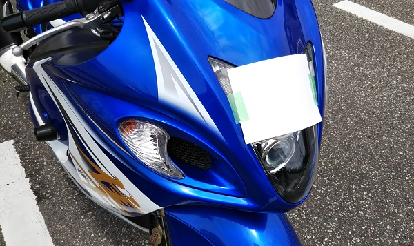 バイク ヘッドライトに紙を貼りつけている様子 光軸合わせ ユーザー車検